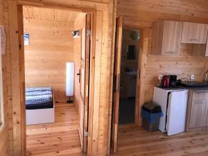 una cocina en una cabaña de madera con una puerta abierta en Cattleya 2, en Wicko