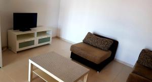ein Wohnzimmer mit einem Stuhl und einem TV in der Unterkunft Casa do Castillo in Fisterra