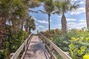a wooden boardwalk with palm trees and plants at Cape Canaveral Escape with Grill Walk to Beach! in Cape Canaveral