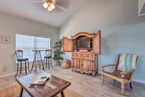a living room with a tv and a table at Cape Canaveral Escape with Grill Walk to Beach! in Cape Canaveral