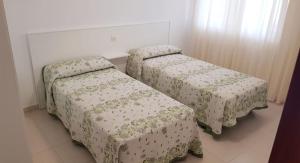2 Einzelbetten in einem Zimmer mit Röcken in der Unterkunft Casa do Castillo in Fisterra