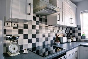a kitchen with black and white checkered tiles on the wall at Finest Retreats - Charnwood in Lewannick
