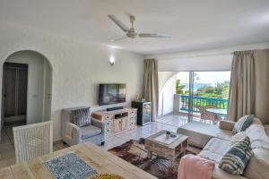 uma sala de estar com um sofá e uma mesa em Serenity At Sea - Santorini Estate - FAMILY ONLY em Ballito