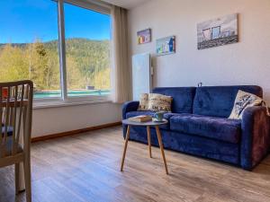 sala de estar con sofá azul y mesa en Appart'Hôtel LIDO au bord de l'eau, en Gérardmer