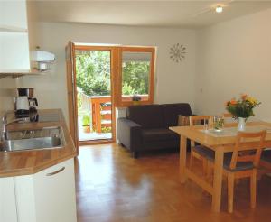 eine Küche und ein Wohnzimmer mit einem Tisch und einem Sofa in der Unterkunft Ferienwohnung Metzenleitner in Berchtesgaden