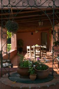 a patio with potted plants and a table and chairs at Posada Don Salvador in San Antonio de Areco
