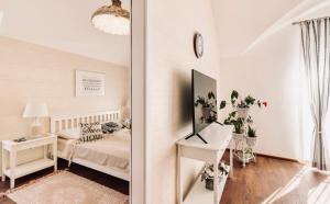 een slaapkamer met een bed en een tafel met een spiegel bij Monarchia Cottage Apartman in Mosonmagyaróvár