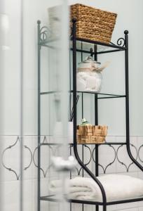 a glass shelf with dishes and a basket on it at Monarchia Cottage Apartman in Mosonmagyaróvár +27 photos