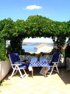 2 sillas y una mesa con vistas al agua en Charming dalmatian apartment with panoramic view, en Tkon