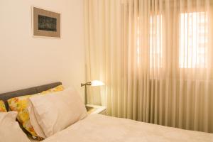 a bedroom with a bed and a window with curtains at Luxurious Huge 5R in Jerusalem center in Jerusalem