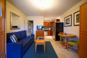 a living room with a blue couch and a table at La Costa Beach Club in Pompano Beach