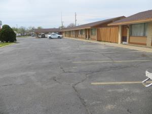 a parking lot with a car parked in front of a building at Traveler's Lodge in Salina