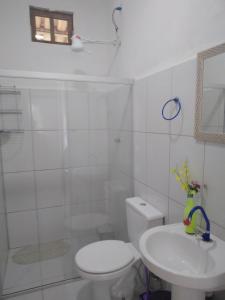 a white bathroom with a toilet and a sink at Res. Orion Praia do Espelho in Praia do Espelho
