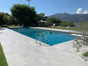 a swimming pool with blue water in a yard at Villa Barbara in Salò