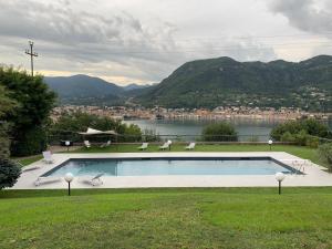 a swimming pool with a view of a river and mountains at Villa Barbara in Salò