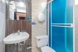 a bathroom with a sink and a toilet and a mirror at Ayenda Castillo Real 1521 in Bucaramanga