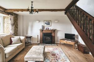 a living room with a couch and a fireplace at Blackdown Cottage in Stockland