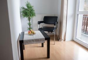 Apartment Haus Sagerer near Attersee and Mondsee في Strass im Attergau: كرسي وطاولة مع صحن من الفاكهة والنبات