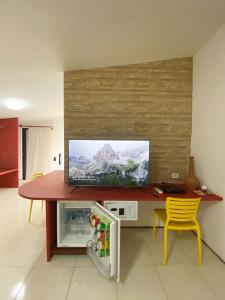 a room with a table with a television on a wall at Pousada Barra Velha in Maragogi