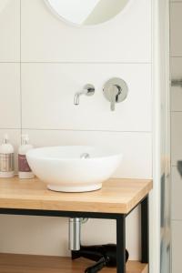 een badkamer met een witte wastafel op een houten aanrecht bij B&B Villa Mimosa in Neerpelt