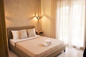 1 dormitorio con 1 cama con 2 toallas en Studios Periklis en Limenas