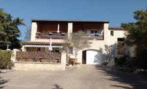 a large stone building with an archway in front of it at Les Lauriers Roses in Salavas