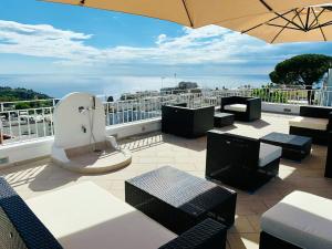 a patio with tables and chairs and an umbrella at Casa Manì in Anacapri