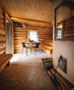 - une salle à manger avec une table et des chaises dans une cabine dans l'établissement Gravas dzirnavas, 