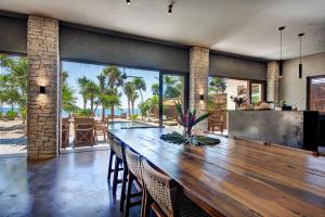 a dining room with a large wooden table and chairs at Beachfront Villa in Tankah Bay in Tulum