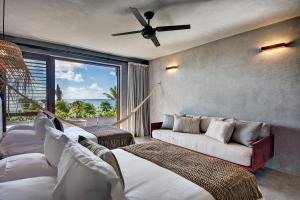 图卢姆Beachfront Villa Soliman Bay 12的客厅配有两张床和吊扇 更多30张照片