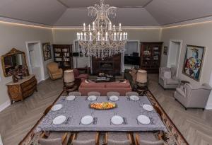 uma sala de estar com uma mesa e um lustre em Casa das Margaridas em Vale de Lobo