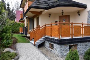 a house with an orange balcony and a walkway at Apartament Erica in Zakopane