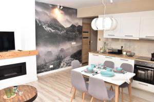 a kitchen and dining room with a table and chairs at Apartament Erica in Zakopane
