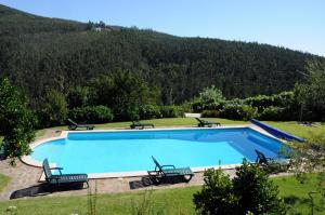 a swimming pool in a yard with a mountain in the background at Quinta Das Escomoeiras in Celorico de Basto
