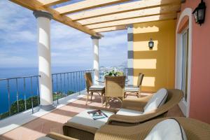 a patio with a table and chairs on a balcony at Balancal Apartments and Villas Palheiro Village by Holiday Rental Madeira in Funchal