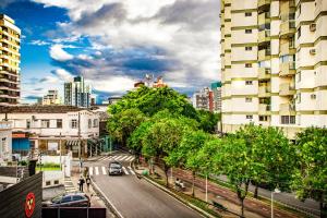 a city street with a car driving down the road at Esquina 8 Suítes Confort & Hostel in Florianópolis