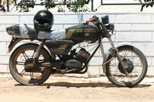 a motorcycle parked in front of a brick wall at B&B Candelária in Loulé