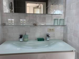 a white bathroom with a sink and a mirror at Vijverhuis in Ieper