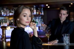 uma mulher sentada num bar com um empregado de bar em Hotel Berghof em Lech am Arlberg