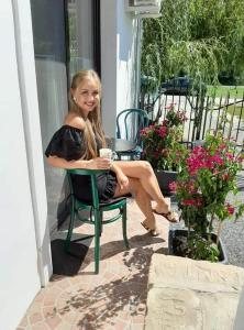 a young girl sitting in a chair on a patio at Piac Vendégház in Káptalantóti