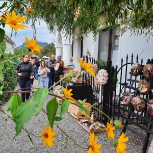 a group of people standing outside a house with flowers at Piac Vendégház in Káptalantóti +20 photos
