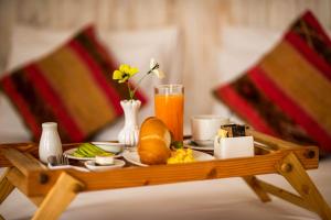 a tray of food and orange juice on a table at El Encanto in Lunahuaná