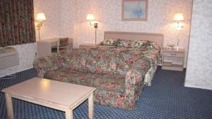 a hotel room with a bed and a couch at Nisei Inn in Gardena +2 photos
