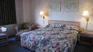 Habitación de hotel con cama y silla en Nisei Inn, en Gardena