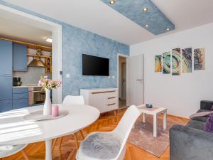 ein Wohnzimmer mit einem weißen Tisch und Stühlen in der Unterkunft Porec TWINS Apartment in Poreč