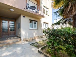 a house with a wooden door and a balcony at Porec TWINS Apartment in Poreč