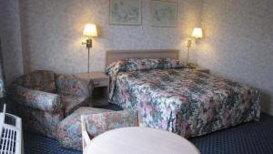 a hotel room with a bed and a chair at Nisei Inn in Gardena