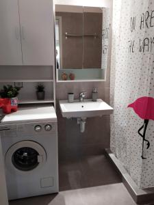 a bathroom with a washing machine and a sink at Home Up in Tríkala