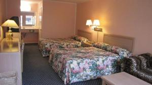 Habitación de hotel con 2 camas y sofá en Nisei Inn, en Gardena