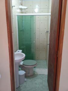 y baño con ducha, aseo y lavamanos. en Residencial Chalés Lunamar Ubatuba, en Ubatuba